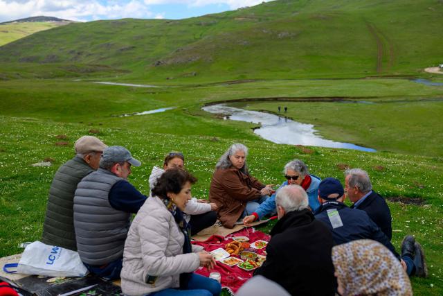 Protesters take a break to eat during a protest march against mining at the Aybasti Plateau in Ordu Province, northeastern Turkey, on May 8, 2026. With Turkey hosting COP31 in November 2026, its own environmental record is being scrutinised, with activists warning about the growing number of water-intensive mining projects as resources dry up. (Photo by Yasin AKGUL / AFP) / TO GO WITH AFP STORY by BURC?N GERCEK