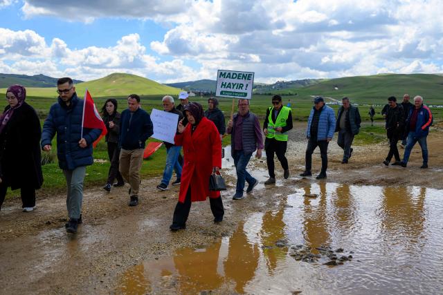 Protesters march as a man holds a placard reading “No to the mine” during a protest march against mining at the Aybasti Plateau in Ordu Province, northeastern Turkey, on May 8, 2026. With Turkey hosting COP31 in November 2026, its own environmental record is being scrutinised, with activists warning about the growing number of water-intensive mining projects as resources dry up. (Photo by Yasin AKGUL / AFP) / TO GO WITH AFP STORY by BURC?N GERCEK