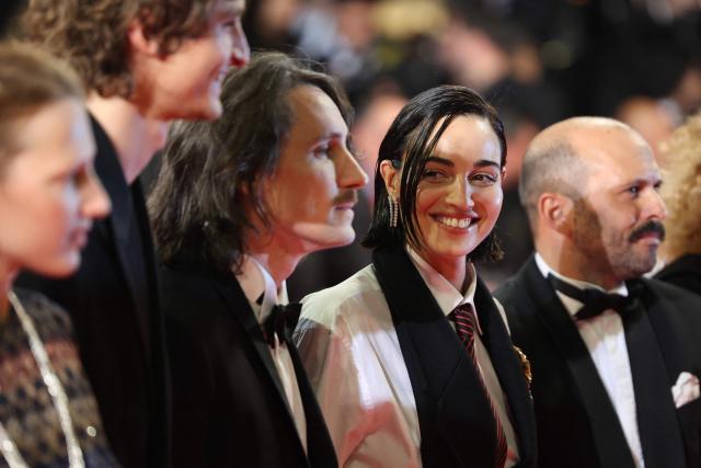 Swiss actress Souheila Yacoub reacts as she poses with French actor Vassili Schneider (2ndL), French director Berenger Thouin (3rdL)and French actor Pierre-Antoine Billon (R) as they arrive for the screening of the film "L'Age d'or" (The Golden Age) at the 79th edition of the Cannes Film Festival in Cannes, southern France on May 13, 2026. (Photo by Thibaud MORITZ / AFP)