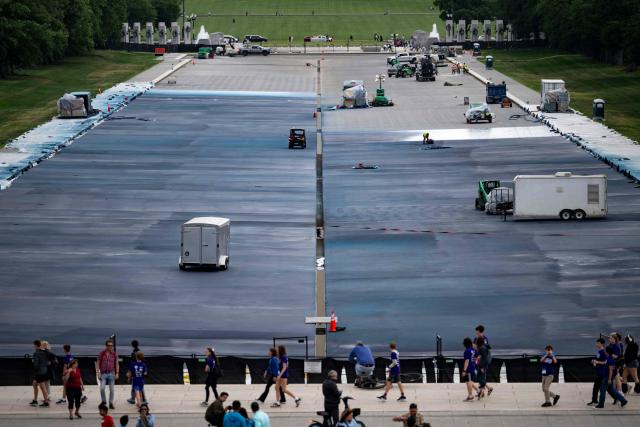 People walk past the Lincoln Memorial Reflecting Pool as it is being resurfaced in Washington, DC, on May 13, 2026. Workers have been resurfacing the bottom of Washington's famous Lincoln Memorial Reflecting Pool with "American flag blue"-colored material used in swimming pools, following an order by US President Donald Trump. (Photo by Kent Nishimura / AFP)