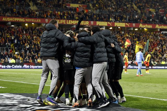 Paris Saint-Germain's players celebrate at the end of the French L1 football match between RC Lens and Paris Saint-Germain (PSG) at the Stade Bollaert-Delelis stadium in Lens on May 13, 2026. Paris Saint-Germain secured their fifth straight Ligue 1 title on May 13, 2026 after a 2-0 win away to nearest rivals Lens gave them an unassailable nine-point lead at the top of the table with one game remaining. (Photo by SIMON WOHLFAHRT / AFP)