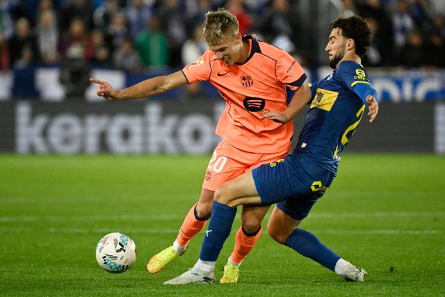 Barcelona's Spanish midfielder #20 Daniel Olmo and Alaves' Spanish defender #24 Victor Parada fight for the ball during the Spanish league football match between Deportivo Alaves and FC Barcelona at Mendizorroza Stadium in Vitoria on May 13, 2026. (Photo by ANDER GILLENEA / AFP)