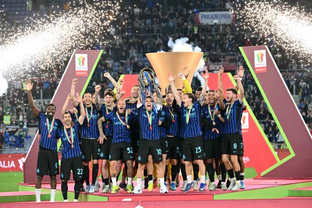 Inter Milan's Argentine forward #10 Lautaro Martinez lifts the trophy of the Italian Cup (Coppa Italia) and celebrates with teammates after Inter won the final football match between Lazio Rome and Inter Milan at the Olympic stadium in Rome on May 13, 2026. (Photo by Alberto PIZZOLI / AFP)