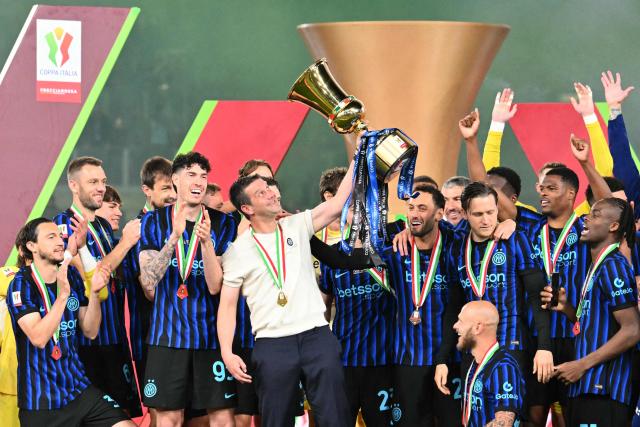 Inter Milan's Romanian head coach Cristian Chivu lifts the trophy of the Italian Cup (Coppa Italia) and celebrates with teammates after Inter won the final football match between Lazio Rome and Inter Milan at the Olympic stadium in Rome on May 13, 2026. (Photo by Alberto PIZZOLI / AFP)