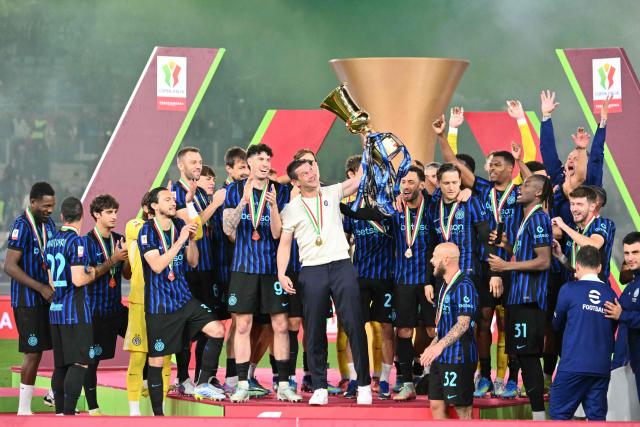 Inter Milan's Romanian head coach Cristian Chivu lifts the trophy of the Italian Cup (Coppa Italia) and celebrates with teammates after Inter won the final football match between Lazio Rome and Inter Milan at the Olympic stadium in Rome on May 13, 2026. (Photo by Alberto PIZZOLI / AFP)