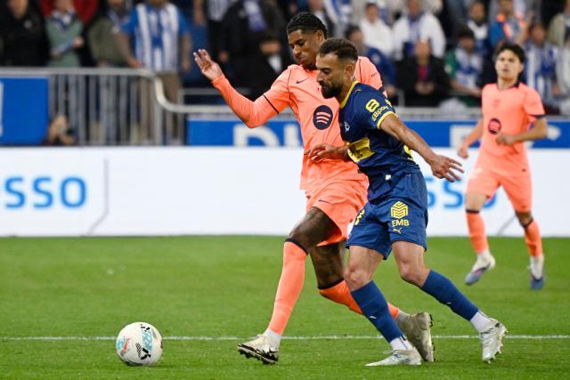 Barcelona's English forward #14 Marcus Rashford (L) and Alaves' Algerian forward #21 Abde Rebbach fight for the ball during the Spanish league football match between Deportivo Alaves and FC Barcelona at Mendizorroza Stadium in Vitoria on May 13, 2026. (Photo by ANDER GILLENEA / AFP)