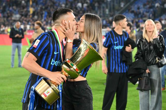 TOPSHOT - Inter Milan's Argentine forward #10 Lautaro Martinez holds the trophy of the Italian Cup (Coppa Italia) and exchanges a kiss with his wife Agustina Gandolfo after Inter won the final football match between Lazio Rome and Inter Milan at the Olympic stadium in Rome on May 13, 2026. (Photo by Alberto PIZZOLI / AFP)