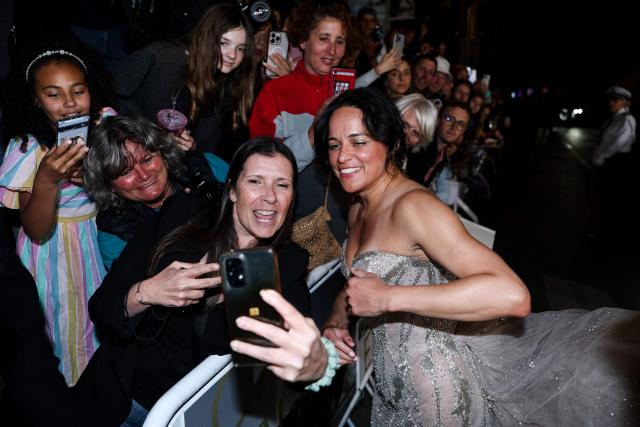 US actress Michelle Rodriguez poses for a selfie with a fan as she arrives for the screening of the film "The Fast and the Furious" at the 79th edition of the Cannes Film Festival in Cannes, southern France on May 13, 2026. (Photo by Sameer AL-DOUMY / AFP)