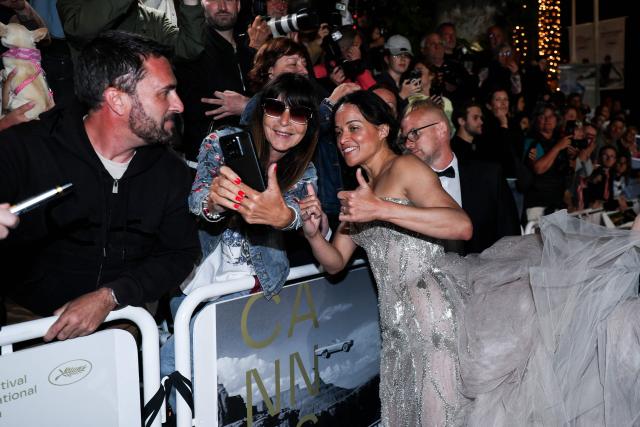 US actress Michelle Rodriguez poses for a selfie with a fan as she arrives for the screening of the film "The Fast and the Furious" at the 79th edition of the Cannes Film Festival in Cannes, southern France on May 13, 2026. (Photo by Sameer AL-DOUMY / AFP)