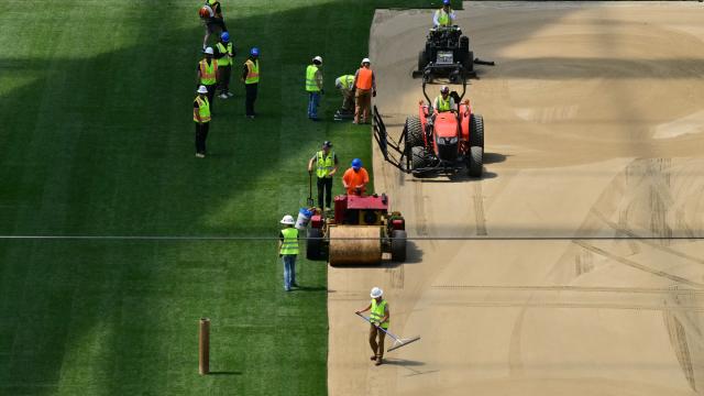 Workers install turf on the pitch at SoFi Stadium in Inglewood, California, ahead of its temporary renaming to Los Angeles Stadium for the World Cup on May 13, 2026. The US Men's National Team will play their first 2026 FIFA World Cup match on June 12 against Paraguay. (Photo by Frederic J. Brown / AFP)