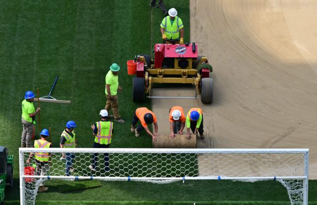Workers install turf on the pitch at SoFi Stadium in Inglewood, California, ahead of its temporary renaming to Los Angeles Stadium for the World Cup on May 13, 2026. The US Men's National Team will play their first 2026 FIFA World Cup match on June 12 against Paraguay. (Photo by Frederic J. Brown / AFP)