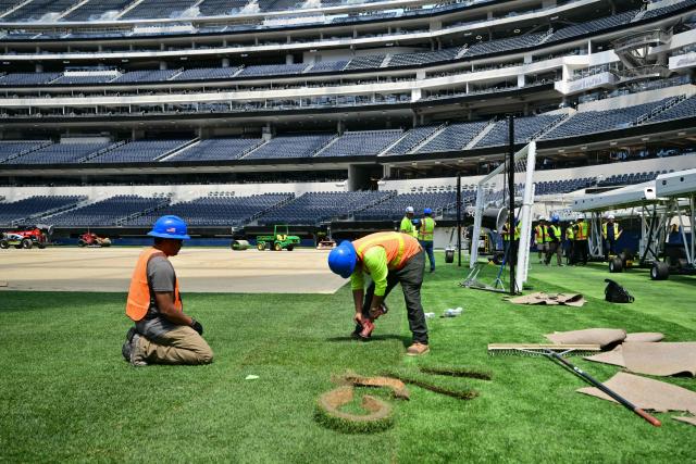 Workers install turf on the pitch at SoFi Stadium in Inglewood, California, ahead of its temporary renaming to Los Angeles Stadium for the World Cup on May 13, 2026. The US Men's National Team will play their first 2026 FIFA World Cup match on June 12 against Paraguay. (Photo by Frederic J. Brown / AFP)