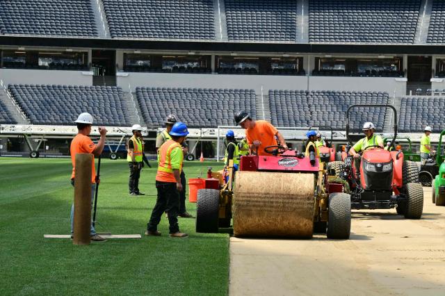Workers install turf on the pitch at SoFi Stadium in Inglewood, California, ahead of its temporary renaming to Los Angeles Stadium for the World Cup on May 13, 2026. The US Men's National Team will play their first 2026 FIFA World Cup match on June 12 against Paraguay. (Photo by Frederic J. Brown / AFP)