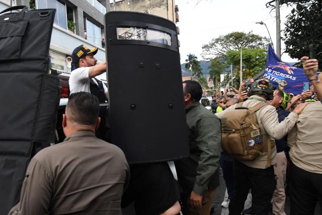 Colombia's right-wing presidential candidate Abelardo de la Espriella, from the Defensores de la Patria movement, is escorted by bodyguards with bulletproof shields as he arrives for a campaign rally in Envigado, Colombia on May 13, 2026. Colombia will hold presidential elections on May 31. (Photo by Jaime SALDARRIAGA / AFP)
