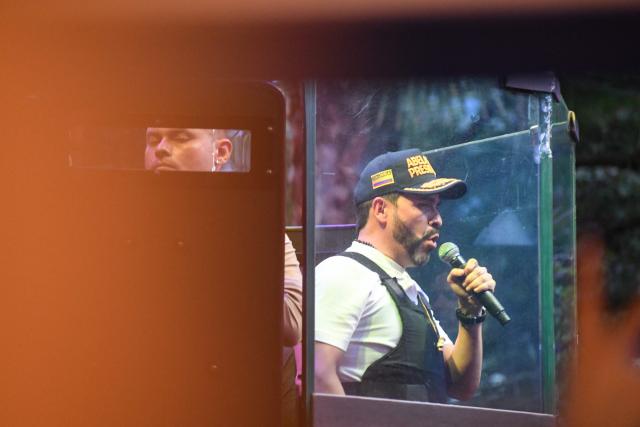 Colombia's right-wing presidential candidate Abelardo de la Espriella, from the Defensores de la Patria movement, speaks behind a bulletproof glass during a campaign rally in Envigado, Antioquia department, Colombia on May 13, 2026. Colombia will hold presidential elections on May 31. (Photo by Jaime SALDARRIAGA / AFP)