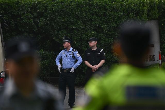 Chinese police officers are seen around the perimeter of the hotel where US President Donald Trump is staying in Beijing on May 14, 2026. (Photo by Pedro Pardo / AFP)