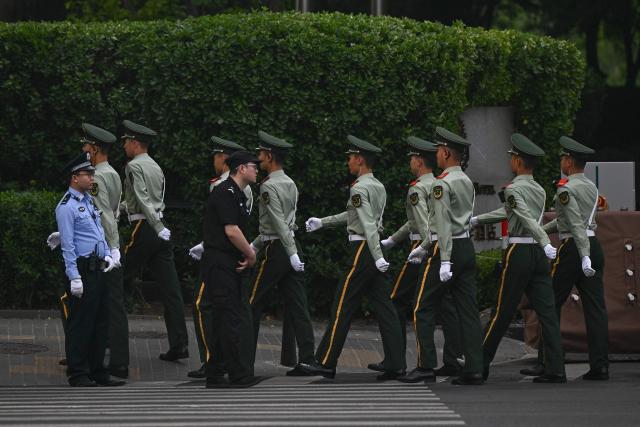 Chinese police officers are seen around the perimeter of the hotel where US President Donald Trump is staying in Beijing on May 14, 2026. (Photo by Pedro Pardo / AFP)
