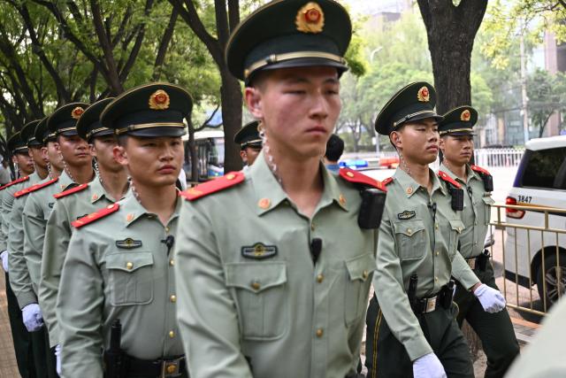 Chinese paramilitary police officers are seen around the perimeter of the hotel where US President Donald Trump is staying in Beijing on May 14, 2026. (Photo by Pedro Pardo / AFP)