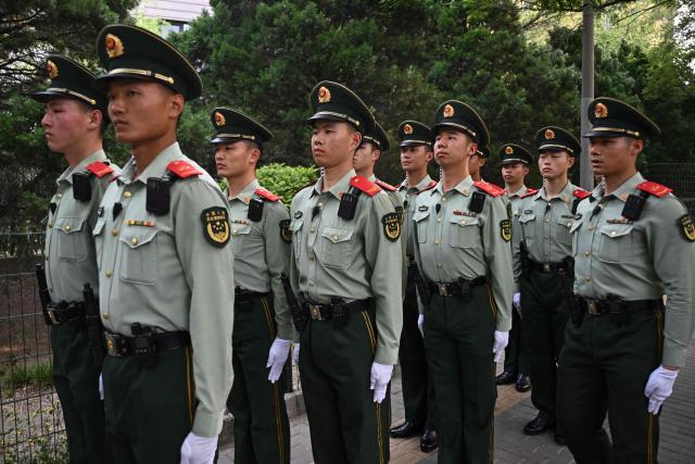 Chinese paramilitary police officers are seen around the perimeter of the hotel where US President Donald Trump is staying in Beijing on May 14, 2026. (Photo by Pedro Pardo / AFP)