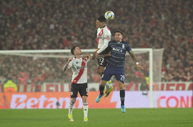 River Plate's defender #13 Lautaro Rivero and Gimnasia y Esgrima La Plata's forward #29 Agustin Auzmendi jump to head the ball next to River Plate's defender #06 Anibal Moreno during the Argentine Professional Football League 2026 Apertura Tournament quarter-final match between River Plate and Gimnasia y Esgrima La Plata at Monumental Stadium in Buenos Aires on May 13, 2026. (Photo by JUAN MABROMATA / AFP)