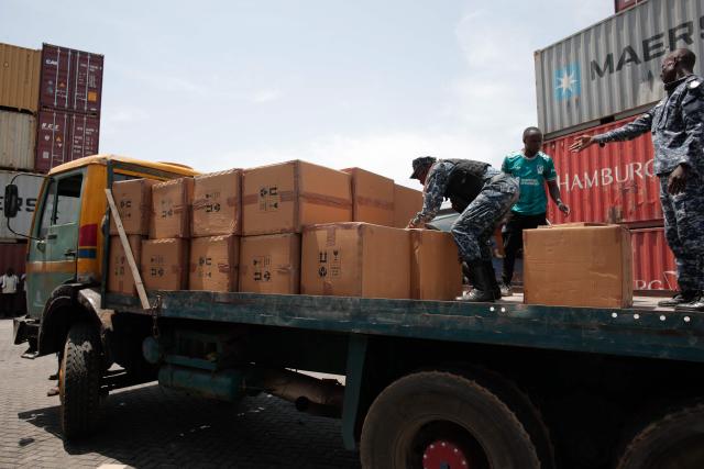 Members of the Transnational Organized Crime Unit (TOCU), a specialized unit of the Sierra Leone Police (SLP) dedicated to combating drug trafficking, organized crime and cross-border criminal activities, load boxes containing Tapentadadol (Tramadol) tablets and capsules into the back of a truck after seizing four 20 feet containers originating from India at the Freetown Terminal in Freetown, on March 27, 2026. In many regions of West Africa, tapentadol is still sold as tramadol, with even authorities using tramadol as a generic umbrella code for all pharmaceutical opioids. Tapentadol pills and capsules, a powerful synthetic opioid that Indian pharmaceutical companies have been exporting to the region in strengths not approved in India, not registered in the destination countries, and not authorised by any recognised international regulatory body. (Photo by Saidu BAH / AFP)
