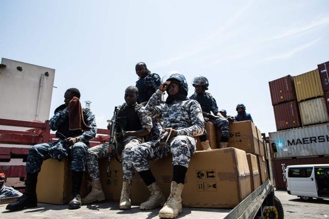 Members of the Transnational Organized Crime Unit (TOCU), a specialized unit of the Sierra Leone Police (SLP) dedicated to combating drug trafficking, organized crime and cross-border criminal activities, guard boxes containing Tapentadadol (Tramadol) tablets and capsules after seizing four 20 feet containers originating from India at the Freetown Terminal in Freetown, on March 27, 2026. In many regions of West Africa, tapentadol is still sold as tramadol, with even authorities using tramadol as a generic umbrella code for all pharmaceutical opioids. Tapentadol pills and capsules, a powerful synthetic opioid that Indian pharmaceutical companies have been exporting to the region in strengths not approved in India, not registered in the destination countries, and not authorised by any recognised international regulatory body. (Photo by Saidu BAH / AFP)