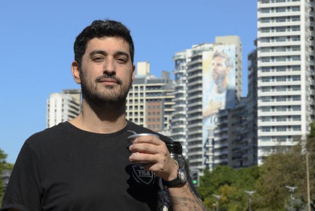 Walter Barrera, a childhood friend of Argentine footballer Lionel Messi, poses near the National Flag Memorial with a mural of Messi in the background in Rosario, Santa Fe province, Argentina, on April 30, 2026. At the age of 12, Lionel Messi ended the career of his first coach. When Enrique Dominguez stopped coaching him in 1999 at the youth club Malvinas Argentinas in the city of Rosario, he resigned, saying he had "already coached the best player in the world", who could now be set to play in his sixth World Cup. (Photo by Marcelo Manera / AFP)