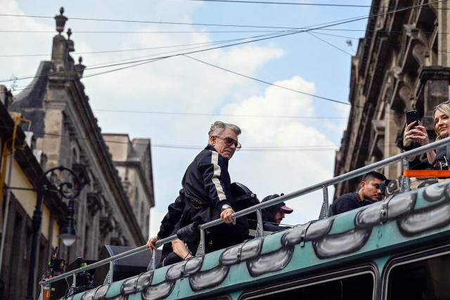 U2 bassist Adam Clayton (L) is seen during the second day of recording of its music video in downtown Mexico City on May 13, 2026. (Photo by Alfredo ESTRELLA / AFP)