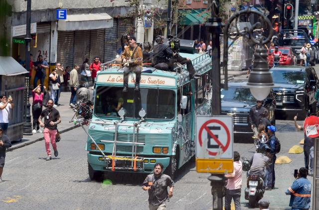 U2 guitarist Dave Evans (C), known as The Edge, performs during the second day of recording of its music video in downtown Mexico City on May 13, 2026. (Photo by Alfredo ESTRELLA / AFP)