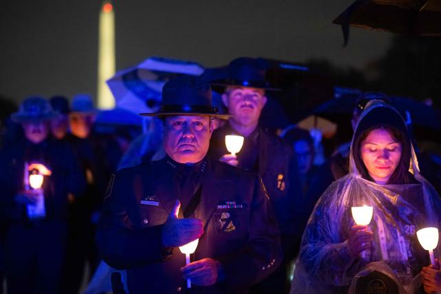 Attendees hold candles during the 38th National Law Enforcement Officers Memorial Fund candlelight vigil commemorating fallen officers at the National Mall in Washington, DC, on May 13, 2026. (Photo by SAUL LOEB / AFP)