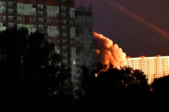 Smoke from an explosion among multi-storey residential buildings is seen during Russian drones and missiles strikes in Kyiv on May 14, 2026, amid the Russian invasion in Ukraine. Ukraine's capital came under heavy aerial attack early on May 14, an AFP journalist reported, as Kyiv's mayor said Russia was striking the city. (Photo by Sergei SUPINSKY / AFP)