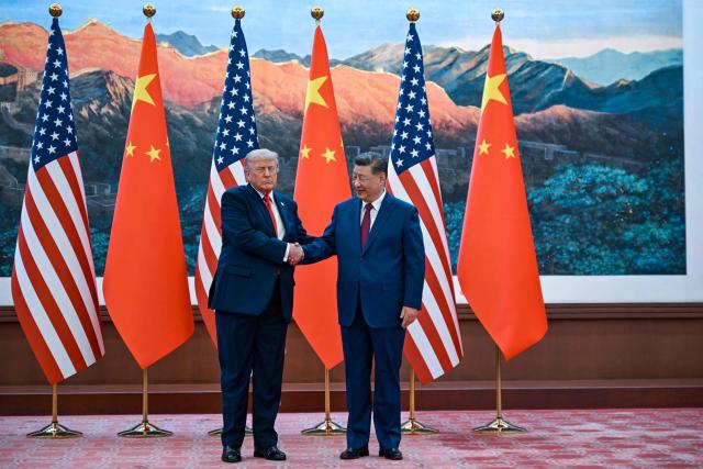 US President Donald Trump (R) shakes hands with China's President Xi Jinping at the Great Hall of the People in Beijing on May 14, 2026. (Photo by Kenny HOLSTON / POOL / AFP)