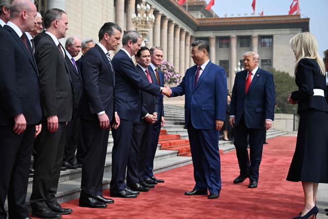 China's President Xi Jinping (C) shakes hands with US Treasury Secretary Scott Bessent as US President Donald Trump (2nd R) looks on during a welcome ceremony at the Great Hall of the People in Beijing on May 14, 2026. (Photo by Kenny HOLSTON / POOL / AFP)