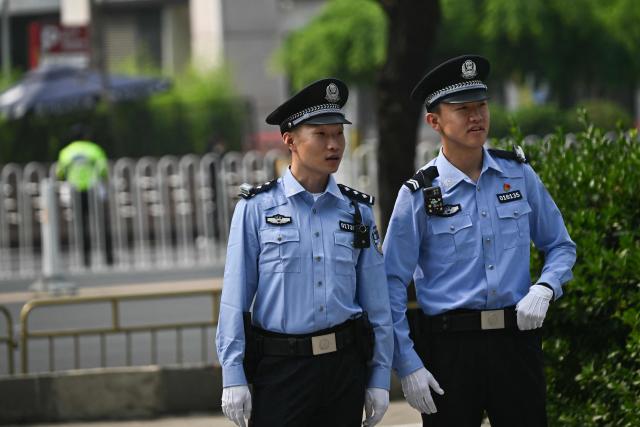 Chinese police officers stand guard at the perimeter of the hotel where US President Donald Trump is staying in Beijing on May 14, 2026. (Photo by Pedro PARDO / AFP)