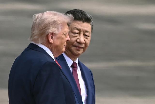 China's President Xi Jinping (R) looks at US President Donald Trump during a welcome ceremony at the Great Hall of the People in Beijing on May 14, 2026. (Photo by Brendan SMIALOWSKI / AFP)