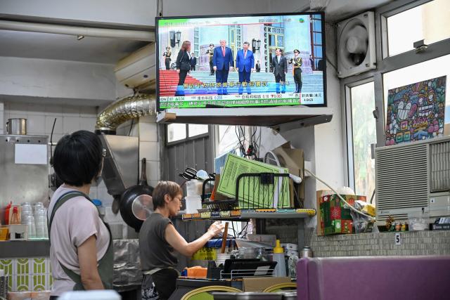A television news programme at a restaurant in Hong Kong on May 14, 2026 shows the meeting between the US President Donald Trump and China's President Xi Jinping in Beijing. Chinese leader Xi Jinping told US President Donald Trump the two countries should be "partners and not rivals" as they met for talks in Beijing on May 14. (Photo by Peter PARKS / AFP)