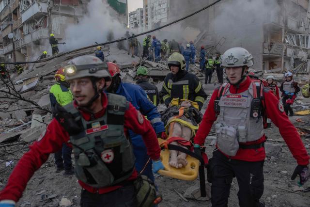 TOPSHOT - Rescuers carry an injured person at the site of a residential building that was partially destroyed following Russian drones and missiles strikes in Kyiv on May 14, 2026, amid the Russian invasion in Ukraine. Ukraine's capital came under heavy aerial attack early on May 14, an AFP journalist reported, as Kyiv's mayor said Russia was striking the city. (Photo by Roman PILIPEY / AFP)