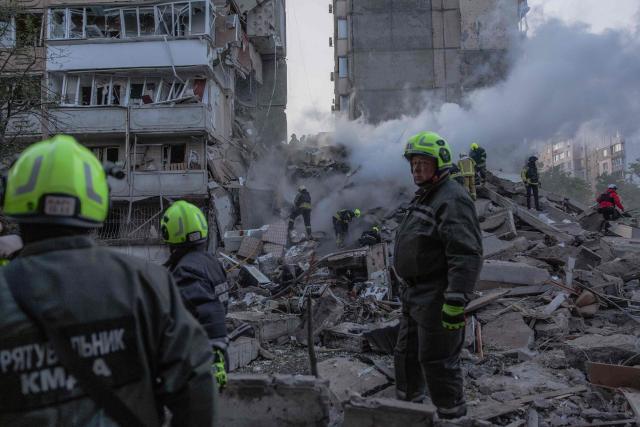Rescuers work at a residential building partially destroyed following Russian drones and missiles strikes in Kyiv on May 14, 2026, amid the Russian invasion in Ukraine. Ukraine's capital came under heavy aerial attack early on May 14, an AFP journalist reported, as Kyiv's mayor said Russia was striking the city. (Photo by Roman PILIPEY / AFP)