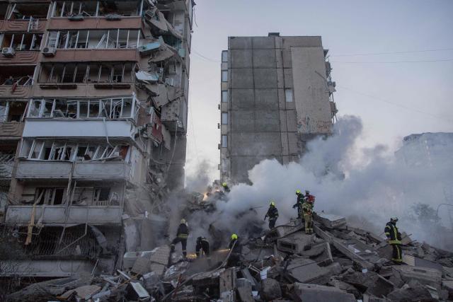 Rescuers work at a residential building partially destroyed following Russian drones and missiles strikes in Kyiv on May 14, 2026, amid the Russian invasion in Ukraine. Ukraine's capital came under heavy aerial attack early on May 14, an AFP journalist reported, as Kyiv's mayor said Russia was striking the city. (Photo by Roman PILIPEY / AFP)