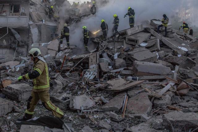 TOPSHOT - Rescuers work at a residential building partially destroyed following Russian drones and missiles strikes in Kyiv on May 14, 2026, amid the Russian invasion in Ukraine. Ukraine's capital came under heavy aerial attack early on May 14, an AFP journalist reported, as Kyiv's mayor said Russia was striking the city. (Photo by Roman PILIPEY / AFP)