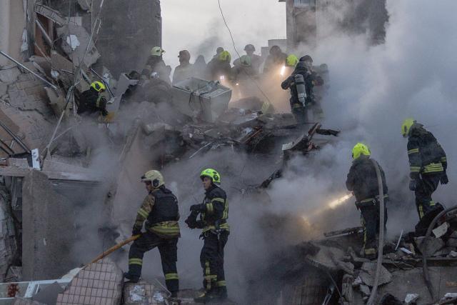 Rescuers work at a residential building partially destroyed following Russian drones and missiles strikes in Kyiv on May 14, 2026, amid the Russian invasion in Ukraine. Ukraine's capital came under heavy aerial attack early on May 14, an AFP journalist reported, as Kyiv's mayor said Russia was striking the city. (Photo by Roman PILIPEY / AFP)