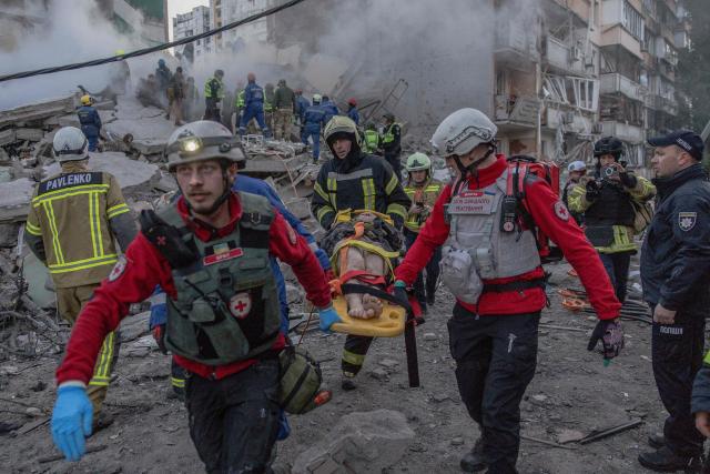 Rescuers carry an injured person at the site of a residential building that was partially destroyed following Russian drones and missiles strikes in Kyiv on May 14, 2026, amid the Russian invasion in Ukraine. Ukraine's capital came under heavy aerial attack early on May 14, an AFP journalist reported, as Kyiv's mayor said Russia was striking the city. (Photo by Roman PILIPEY / AFP)