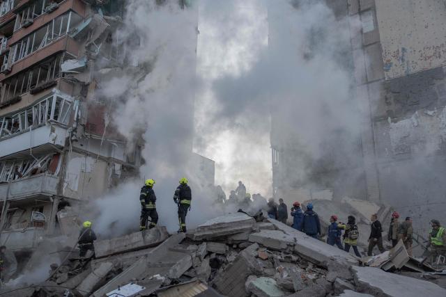 Rescuers work at a residential building partially destroyed following Russian drones and missiles strikes in Kyiv on May 14, 2026, amid the Russian invasion in Ukraine. Ukraine's capital came under heavy aerial attack early on May 14, an AFP journalist reported, as Kyiv's mayor said Russia was striking the city. (Photo by Roman PILIPEY / AFP)
