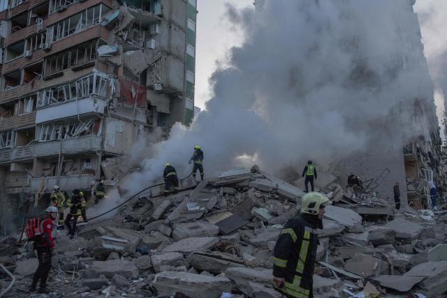 Rescuers work at a residential building partially destroyed following Russian drones and missiles strikes in Kyiv on May 14, 2026, amid the Russian invasion in Ukraine. Ukraine's capital came under heavy aerial attack early on May 14, an AFP journalist reported, as Kyiv's mayor said Russia was striking the city. (Photo by Roman PILIPEY / AFP)