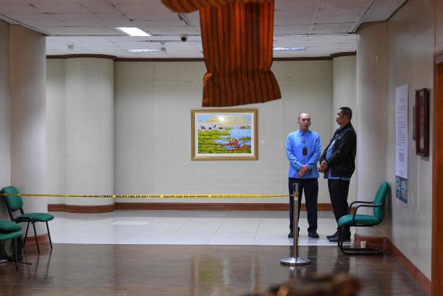 Senate security personnel stand guard near the site where gun shots were fired night before inside the Senate building in Manila on May 14, 2026. Police said May 14 they detained a person in connection with gunfire the previous night inside the Philippine senate, where a lawmaker wanted by the International Criminal Court took refuge. (Photo by TED ALJIBE / AFP)