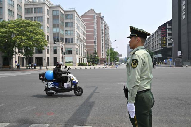A traffic control officer is seen on a street in Beijing on May 14, 2026, amid a state visit by US President Donald Trump. (Photo by Hector RETAMAL / AFP)