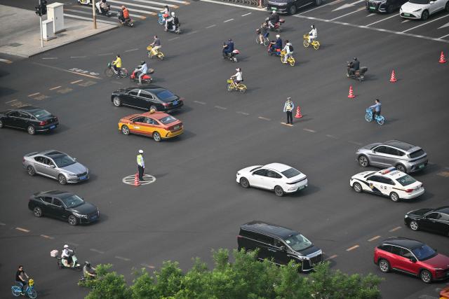 A general view shows motorists on a street in Beijing on May 14, 2026, amid a state visit by US President Donald Trump. (Photo by Hector RETAMAL / AFP)