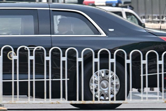 US President Donald Trump is pictured in his official vehicle known as "The Beast" as the motorcade drives through Beijing on May 14, 2026. (Photo by HECTOR RETAMAL / AFP)