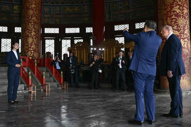 China's President Xi Jinping (2nd R) and US President Donald Trump (R) visit the Temple of Heaven in Beijing on May 14, 2026. Xi warned Trump that the issue of Taiwan could push their two countries into "conflict" if mishandled, a stark opening salvo as a superpower summit set to tackle numerous thorny issues began in Beijing on May 14. (Photo by Brendan SMIALOWSKI / POOL / AFP)