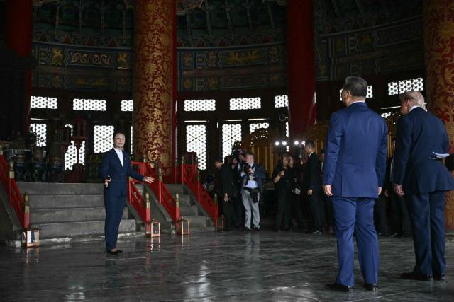 China's President Xi Jinping (2nd R) and US President Donald Trump (R) visit the Temple of Heaven in Beijing on May 14, 2026. Xi warned Trump that the issue of Taiwan could push their two countries into "conflict" if mishandled, a stark opening salvo as a superpower summit set to tackle numerous thorny issues began in Beijing on May 14. (Photo by Brendan SMIALOWSKI / POOL / AFP)